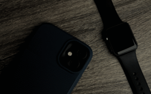 A close-up view of a smartphone and smartwatch in a dark setting, showcasing the integration of mobile technology and wearable devices.