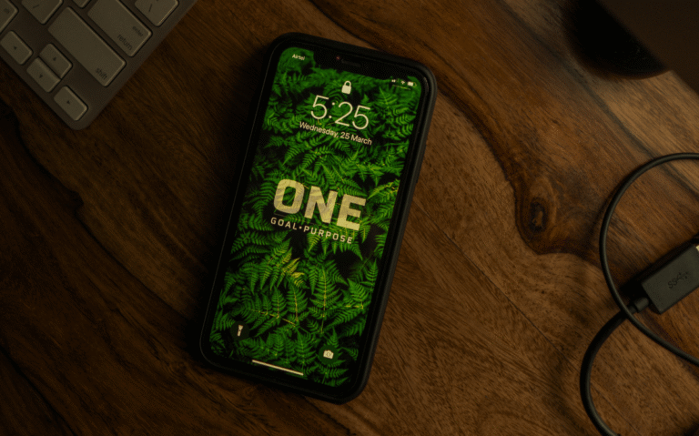 A smartphone screen displaying the time and date against a lush, nature-inspired background, suggesting the integration of technology with environmental aesthetics.